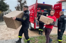 Druhowie niosący paczki z auta gaśniczego